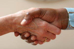 Helping hand shakes another in an agreement
