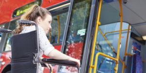 Disabled Woman In Wheelchair Boarding Bus