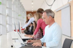 teacher working on laptop computer in classroom