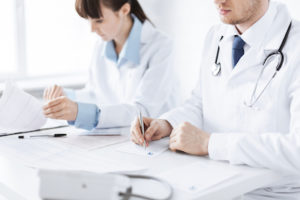 doctor and nurse writing prescription paper