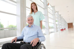Nurse helping senior man in wheelchair